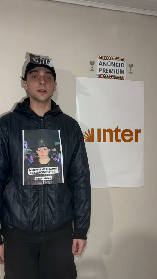 Eduardo ao lado do anúncio laranja do Banco Inter